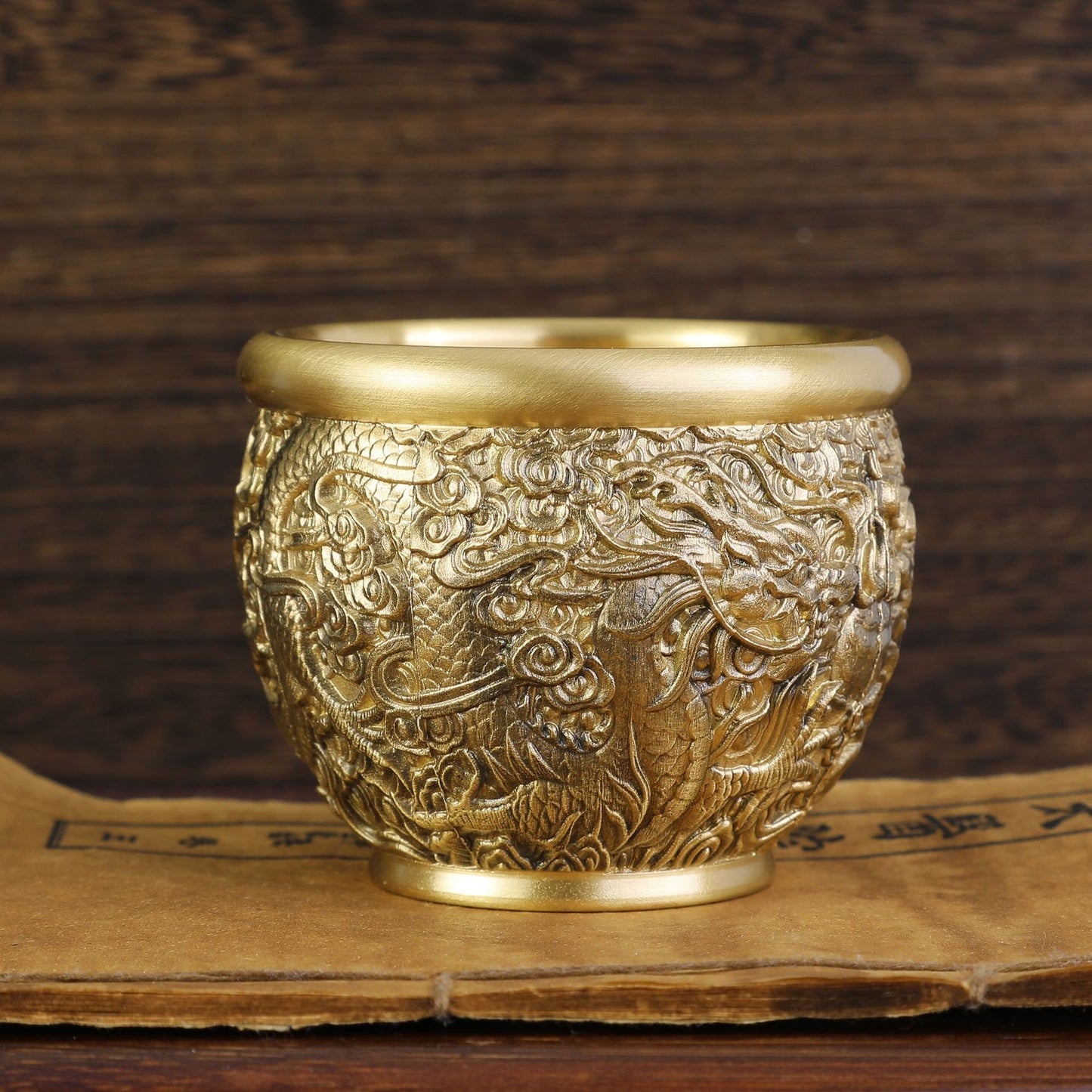Ancient Chinese dragon coiled around bronze cornucopia jar on red silk